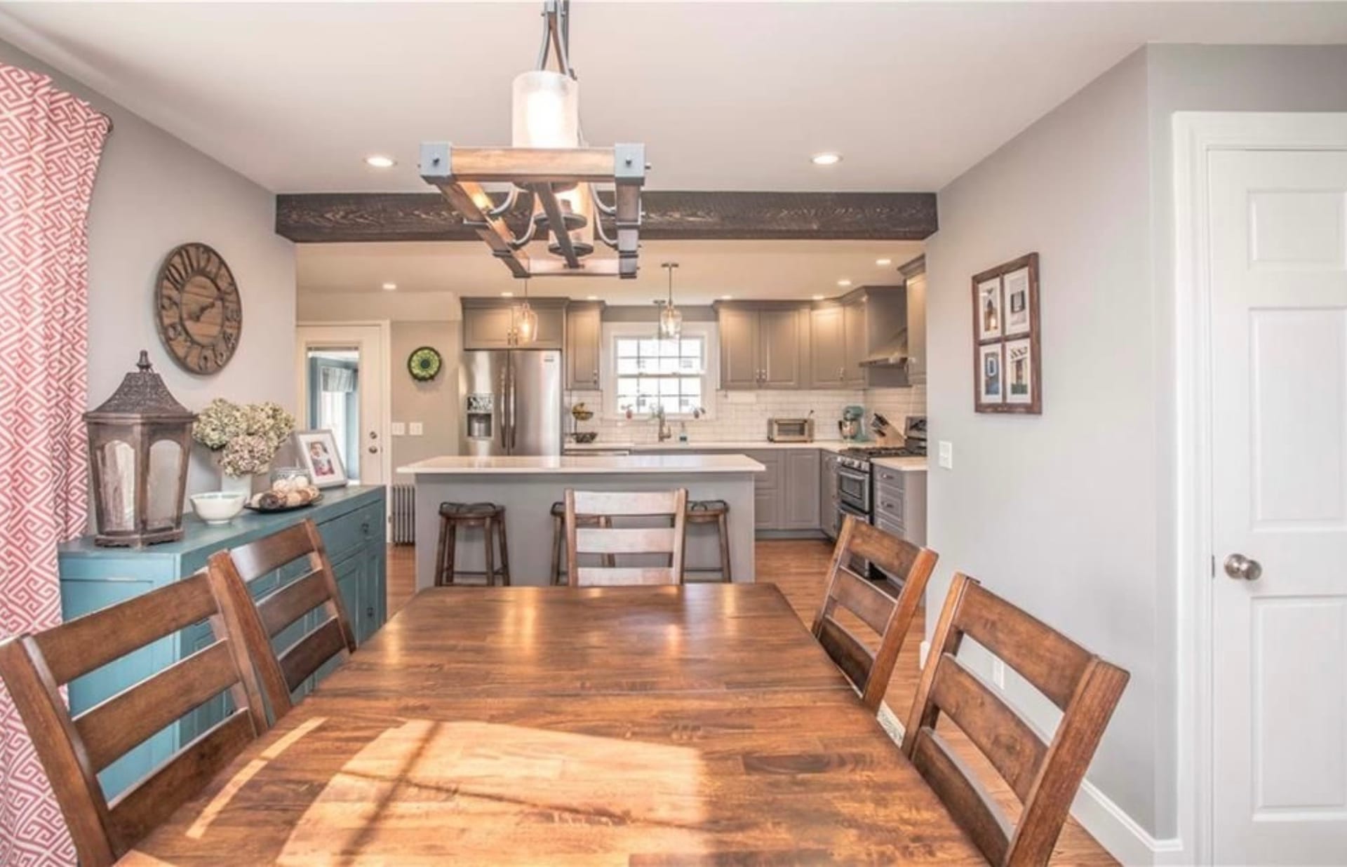 Dining room opening into renovated kitchen with decorative beam